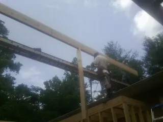 Carpenter setting a ridge beam over a new addition frame — Ice Dam Removal by Roofing Brothers in Luther