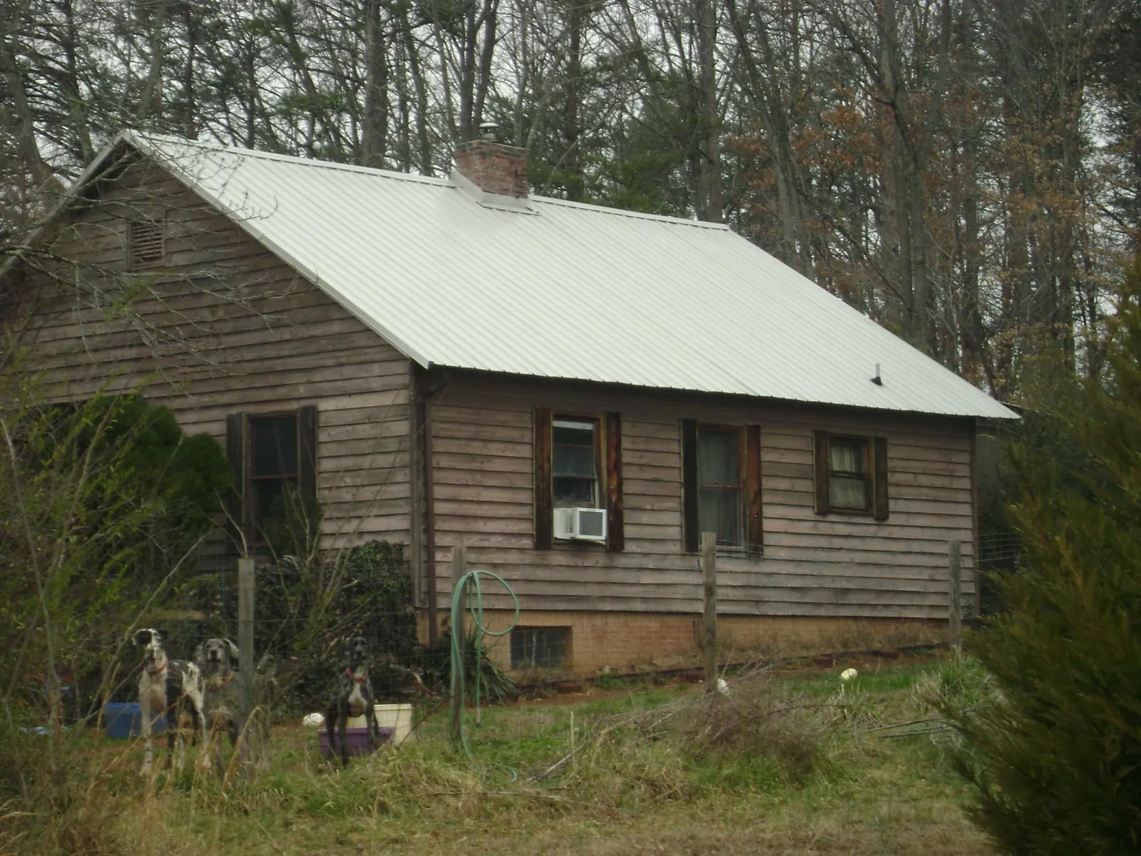 White metal roof on an old wood sided farmhouse, from a Metal Roof Installation job in Luther